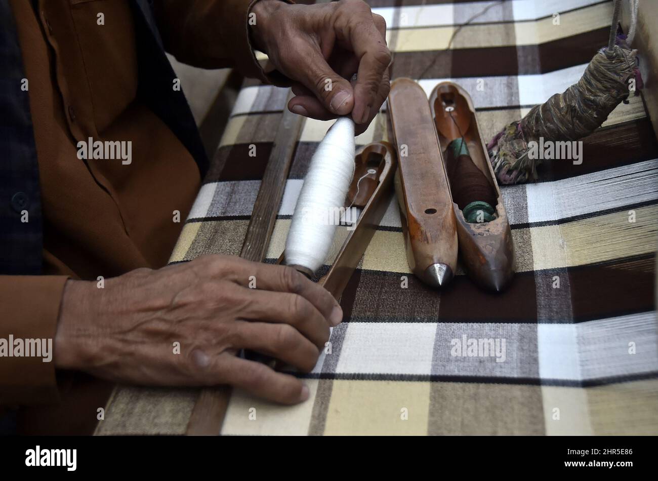 Charsada. 25.. Februar 2022. Am 25. Februar 2022 arbeitet ein Mann in einer traditionellen Schalwellfabrik am Stadtrand von Charsadda im Nordwesten Pakistans. Quelle: Saeed Ahmad/Xinhua/Alamy Live News Stockfoto