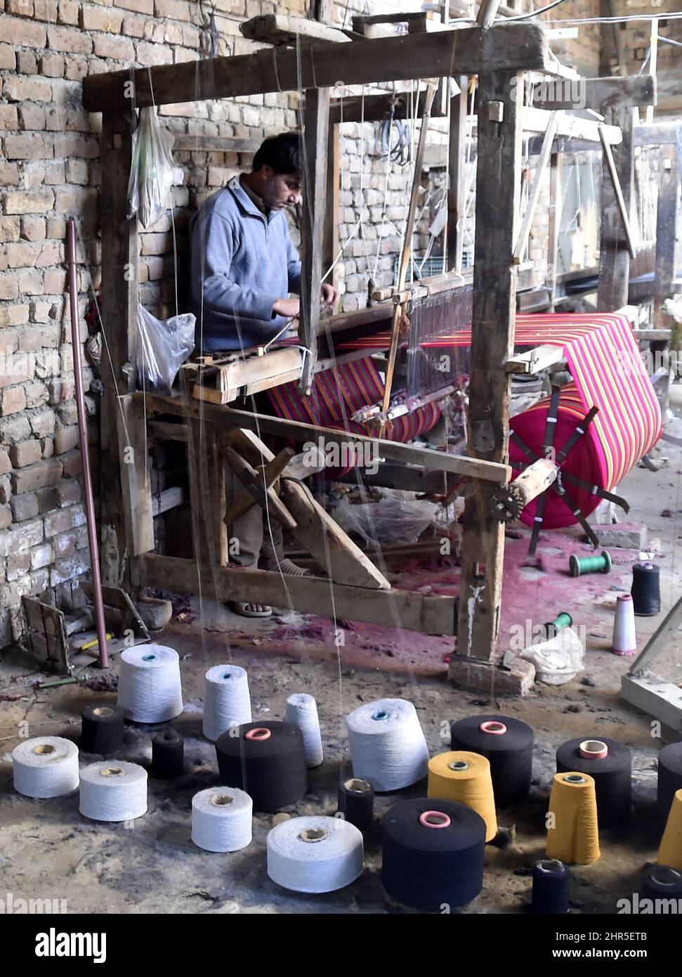 Charsada. 25.. Februar 2022. Am 25. Februar 2022 arbeitet ein Mann in einer traditionellen Schalwellfabrik am Stadtrand von Charsadda im Nordwesten Pakistans. Quelle: Saeed Ahmad/Xinhua/Alamy Live News Stockfoto