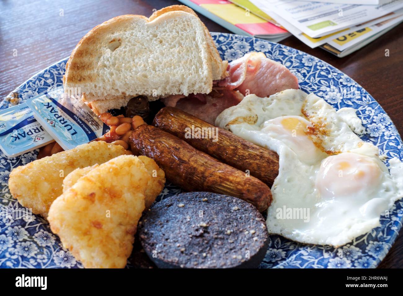 Ein großes Wetherspoons Frühstück wird in einem Wetherspoons Pub serviert. Das Frühstück ist 1406 Kalorien. Der zusätzliche Blutwurst fügt zusätzliche 352 Kalorien hinzu Stockfoto