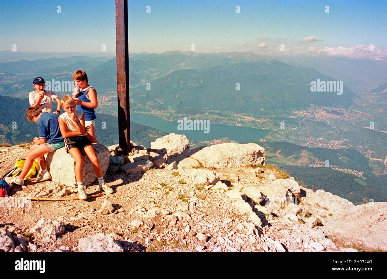 Kinder neben Gipfelkreuz, Becco di Filadonna, 05. August 1988, Caldonazzo-See im Hintergrund, Trentino, Italien Stockfoto