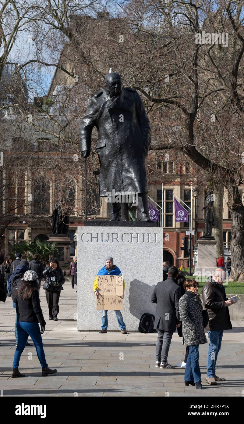 Parliament Square, London, Großbritannien. 25. Februar 2022. A , auf dem Parliament Square am 2. Tag der Invasion durch Russland, drapiert mit einer ukrainischen Flagge. Er hält ein Plakat, auf dem die NATO aufgefordert wird, jetzt zu handeln. Quelle: Malcolm Park/Alamy Live News Stockfoto