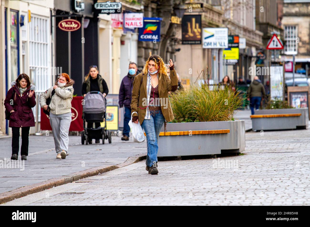 Dundee, Tayside, Schottland, Großbritannien. 25.. Februar 2022. Britisches Wetter: Temperaturen von bis zu 8 Grad Celsius, kombiniert mit strahlendem Sonnenschein, sorgten für einen atemberaubenden Tag in Nordostschottland. Nach monatelangen Covid-Lockdown-Regeln wurde das Omicron entspannt; außen sind keine Gesichtsbezüge mehr erforderlich, innen sind jedoch Gesichtsmasken erforderlich. Die Bewohner von Dundee sind unterwegs und nutzen die Wintersonne, während sie sich im Stadtzentrum unterhalten und einkaufen. Kredit: Dundee Photographics/Alamy Live Nachrichten Stockfoto