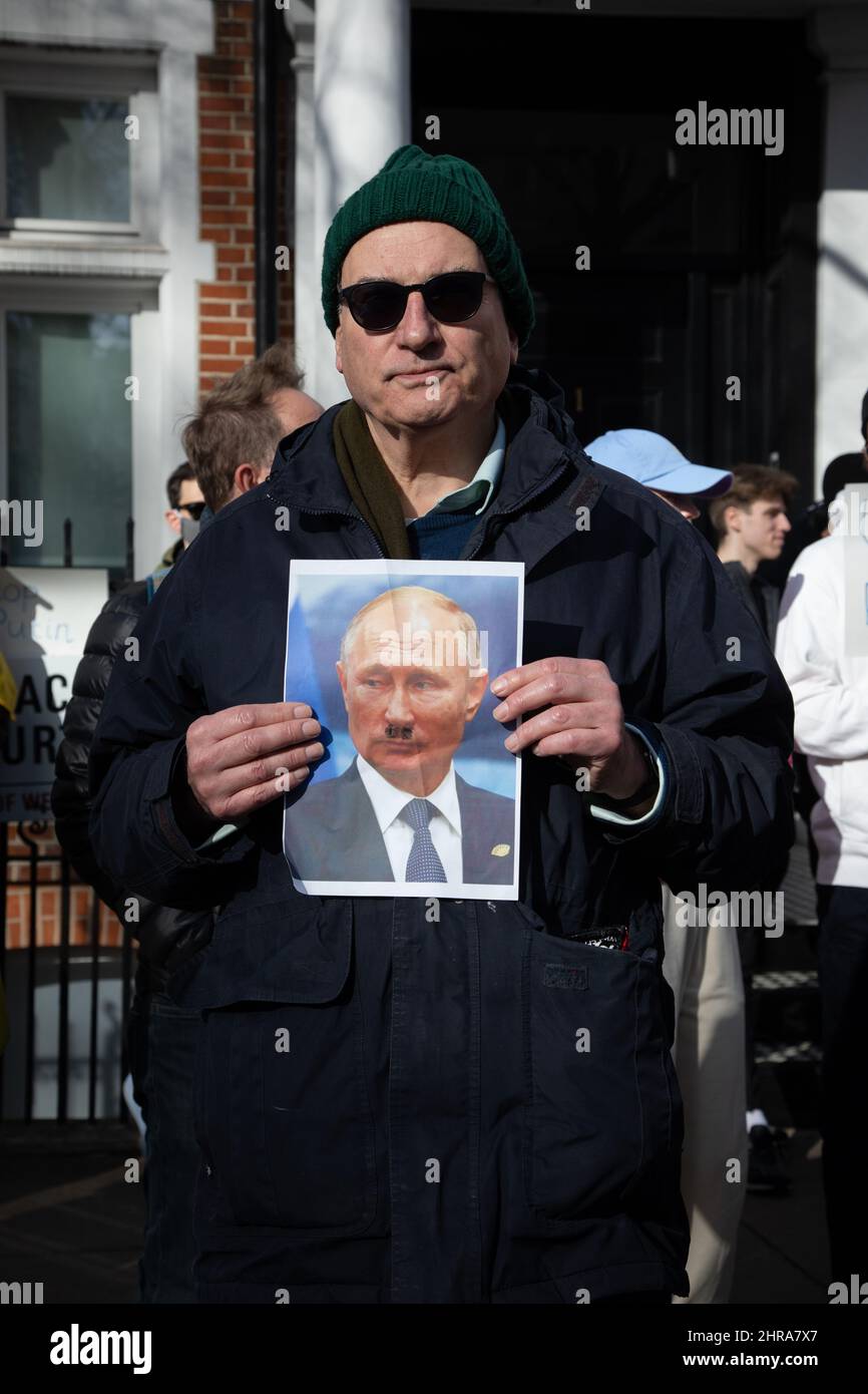 London, Großbritannien. 25.. Februar 2022. Ein Protestler hält vor der russischen Botschaft in London ein Schild, auf dem Wladimir Putin mit einem Hitler-Schnurrbart abgebildet ist, um gegen die jüngsten Angriffe Russlands auf die Ukraine zu protestieren. London, 25.2.2022 Credit: Kiki Streitberger/Alamy Live News Credit: Kiki Streitberger/Alamy Live News Stockfoto