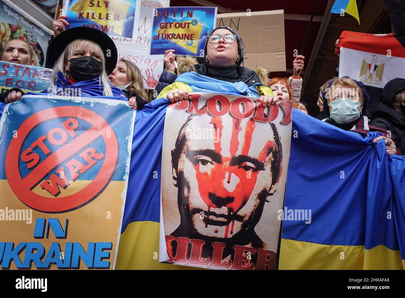 Ein Protestler hält ein Porträt von Wladimir Putin und eine riesige ukrainische Flagge, während er während der Demonstration Parolen singt.Ukrainische Bürger aus Istanbul versammelten sich vor dem russischen Generalkonsulat im Bezirk Beyo?lu und protestierten gegen die russische Militäroperation gegen die Ukraine. Die Protestierenden riefen unter dem Motto „Killer Putin“ und hielten Transparente mit „Nein zum Krieg“ und „Stoppt den Krieg“ auf und forderten, dass der Krieg gestoppt werden sollte So bald wie möglich während die Polizei umfassende Sicherheitsmaßnahmen ergriff, brachen einige Ukrainer in Tränen aus. Stockfoto