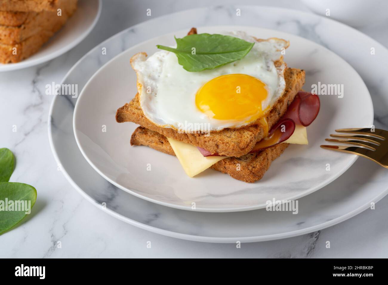 Sandwich mit einem Spiegelei, Speck, Käse und Spinat Stockfoto