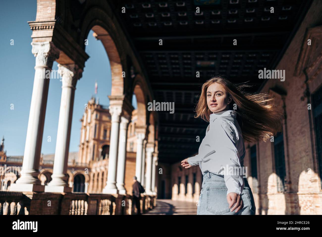 Junge lächelnde kaukasische Frau kehrt zurück Sightseeing in Europa Stockfoto