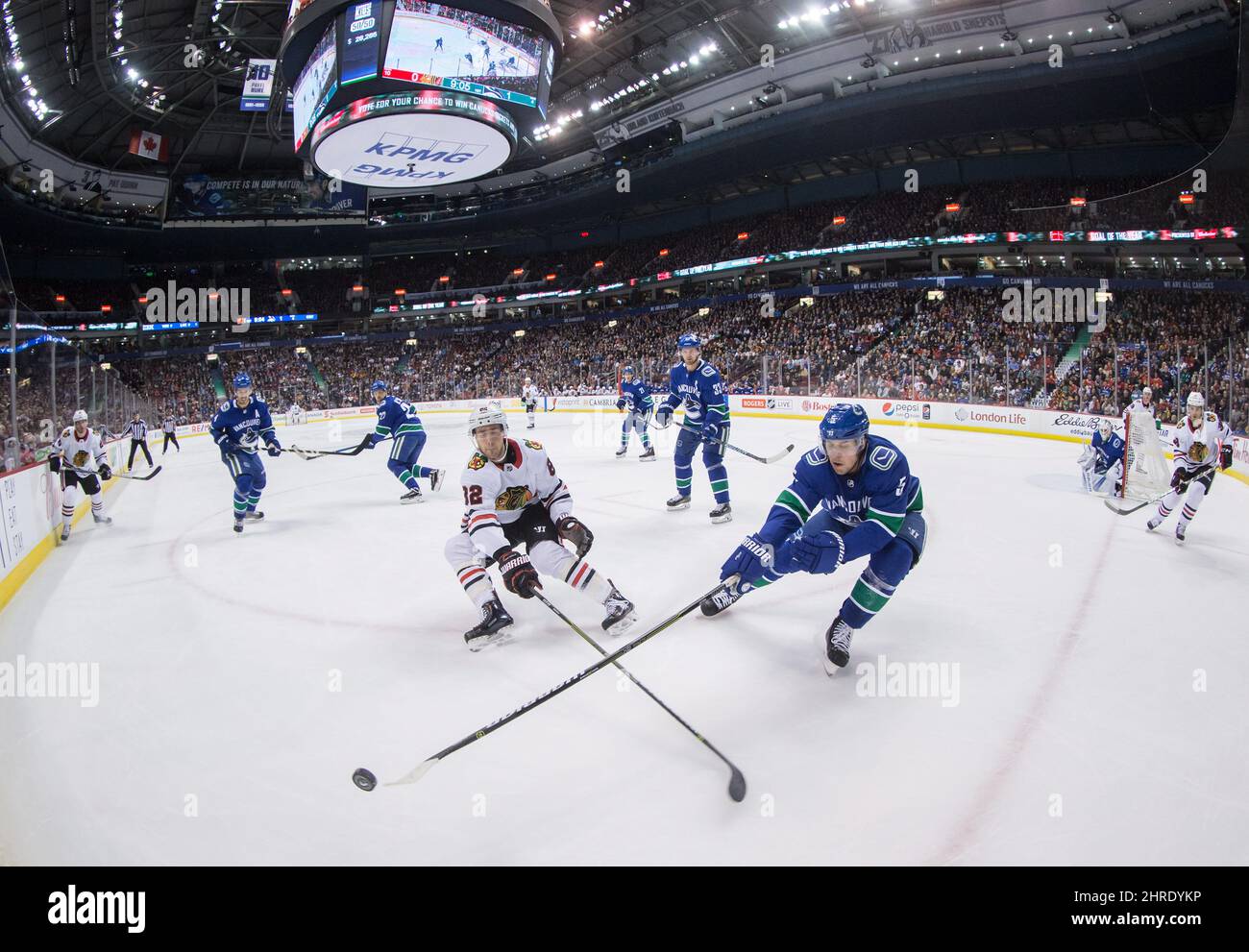 Chicago Blackhawks' Jordan Oesterle, links, und Vancouver Canucks' Derrick Pouliot greifen während der ersten Periode eines NHL-Hockeyspiels in Vancouver, B.C., am Donnerstag, dem 28. Dezember 2017, nach dem Puck. DIE KANADISCHE PRESSE/Darryl Dyck Stockfoto