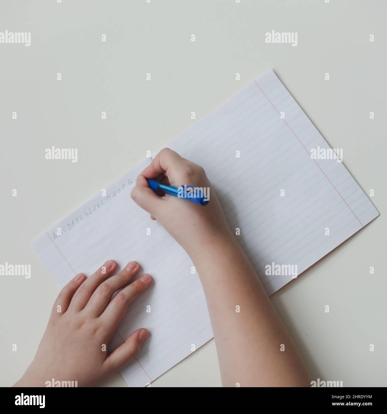 Die Hände des Schülers schreiben in offenem Notizbuch, Draufsicht, Kopierbereich. Stockfoto