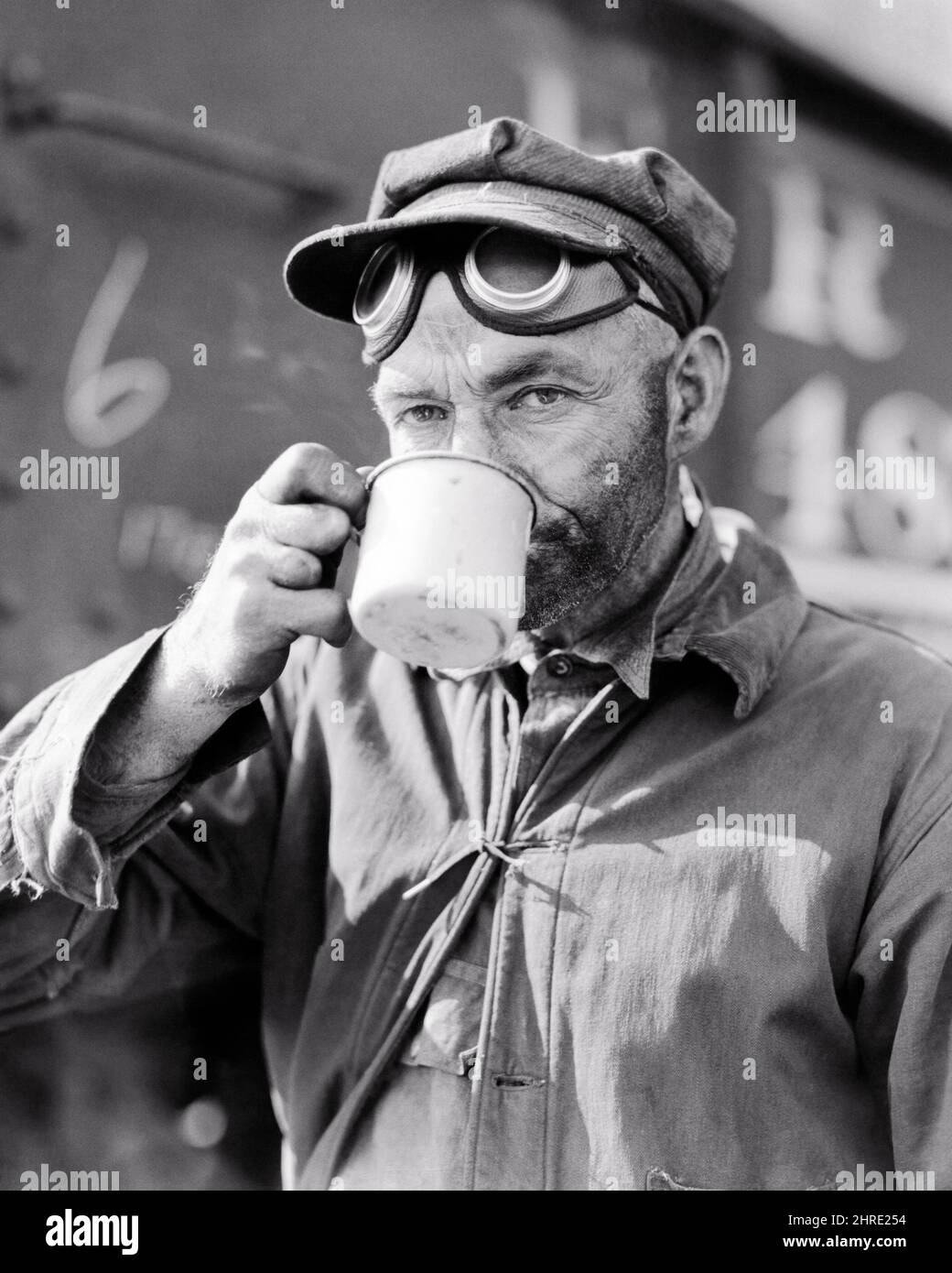 1940S KOHLEBERGARBEITER TRINKT AUS ZINN CUP-BRILLE AUF DER STIRN BLICK AUF KAMERA ARBEITEN IN SURFACE MINING-UNTERNEHMEN IN DER NÄHE VON DU QUOIN IL - I570 HAR001 HARS B&W BLICKKONTAKT BERUF BERGMANN DU CARBON ARBEIT BESCHÄFTIGUNG BERGBAU IN DER NÄHE BERUFE UNTERNEHMEN VERBRAUCHEN KONSUM HYDRATATION MITARBEITER KOHLE STAUB KOHLE BERGMANN STAUBIGEN MITTLEREN ERWACHSENEN MITTLEREN ERWACHSENEN MANN QUOIN ERFRISCHENDE SCHWARZ-WEISS KAUKASISCHEN ETHNIE FOSSILEN BRENNSTOFF HAR001 IL ARBEITEN ALTMODISCH Stockfoto