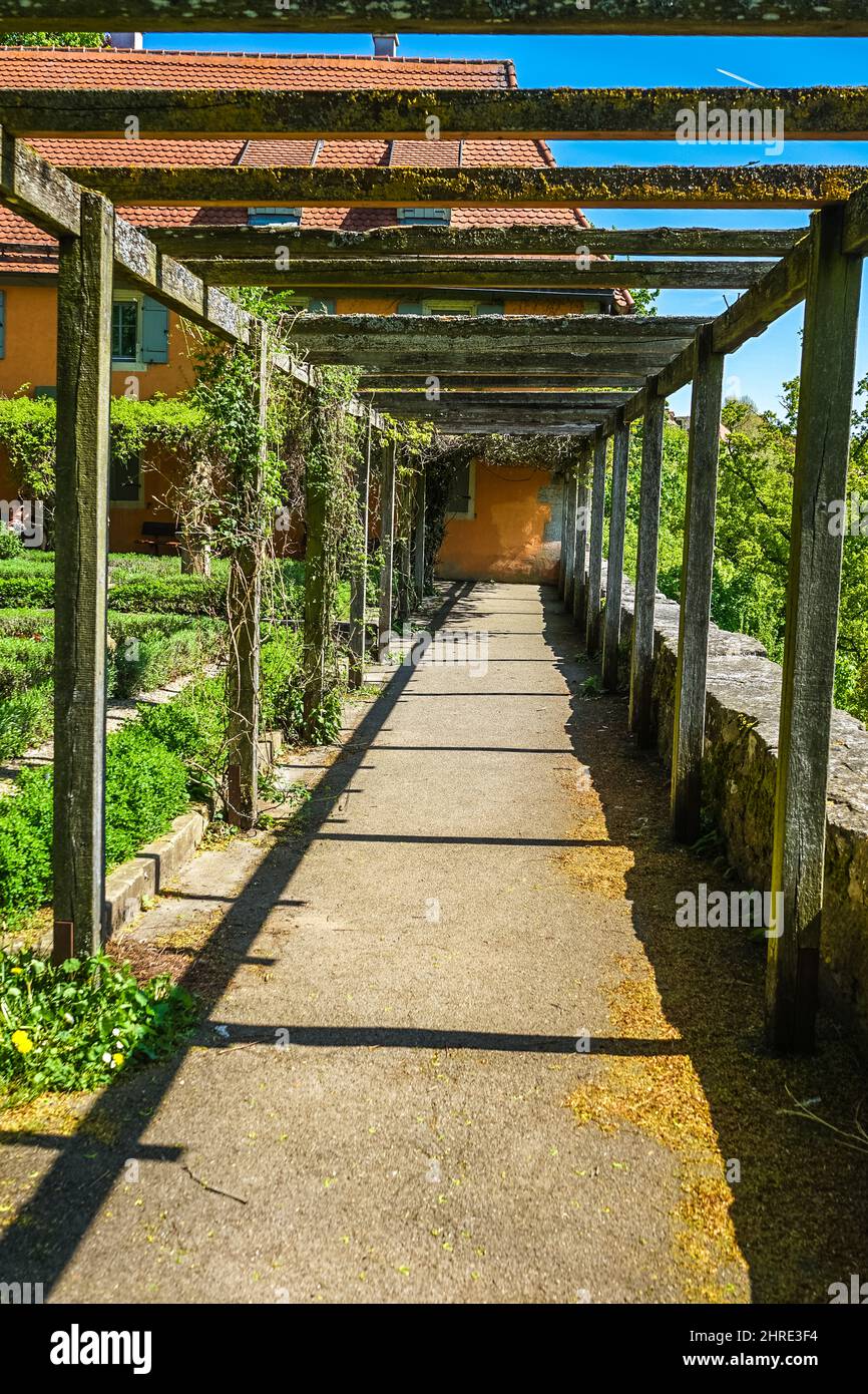 Holzstämme über einem Weg gegen ein Gebäude Stockfoto