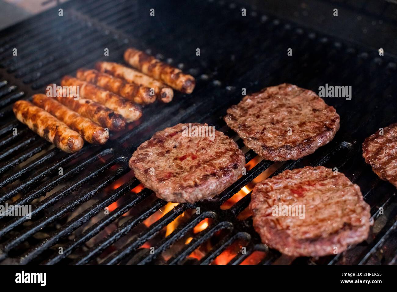 Rauchiges Hamburger-Grillfleisch für Burger. Am offenen Feuer auf dem Grill  braten - bbq. Burger und Würstchen Kochen über Flammen auf dem Grill  Stockfotografie - Alamy