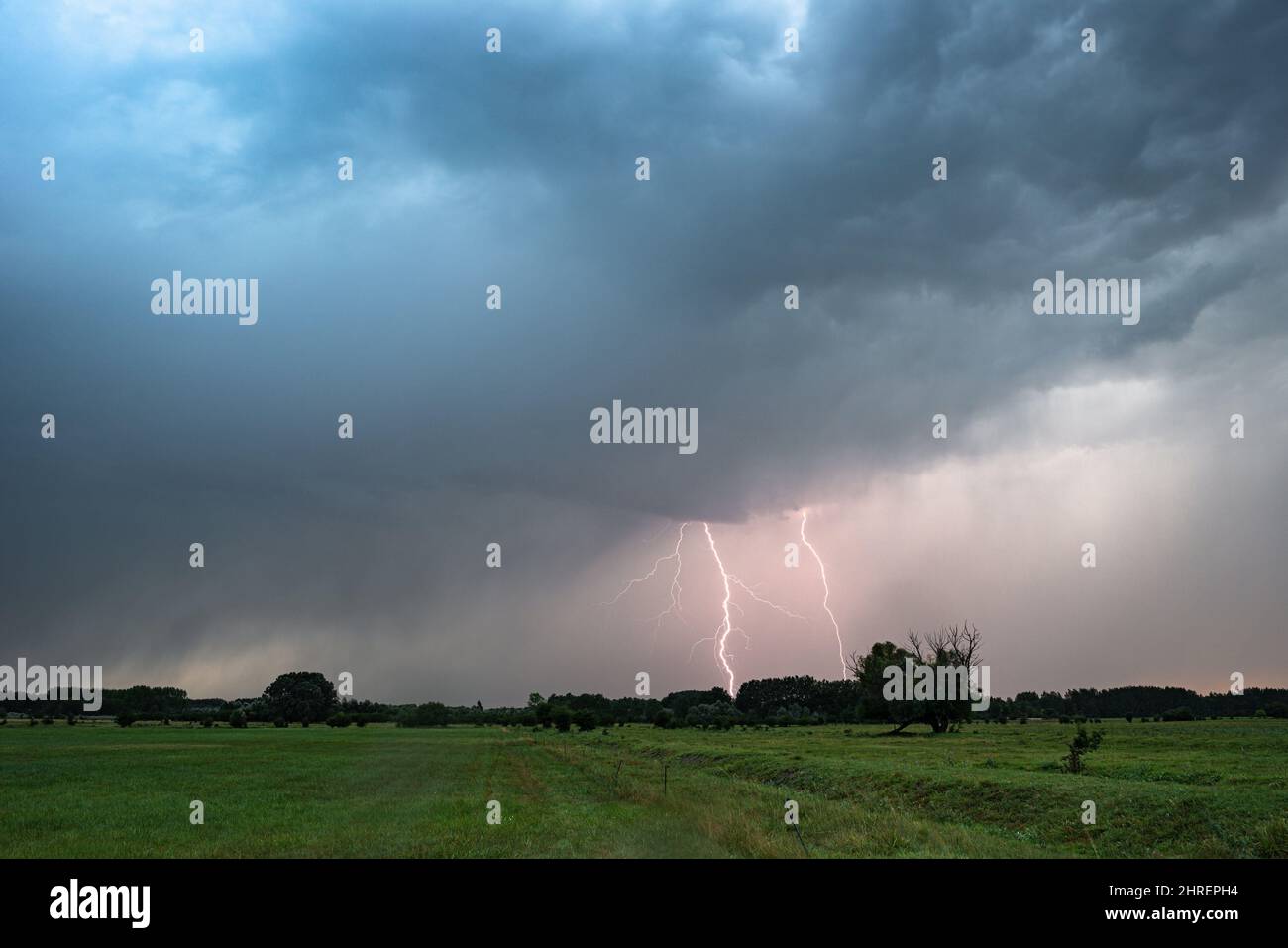 In der Abenddämmerung schlagen zwei Blitzeinschläge auf die Ebenen Stockfoto