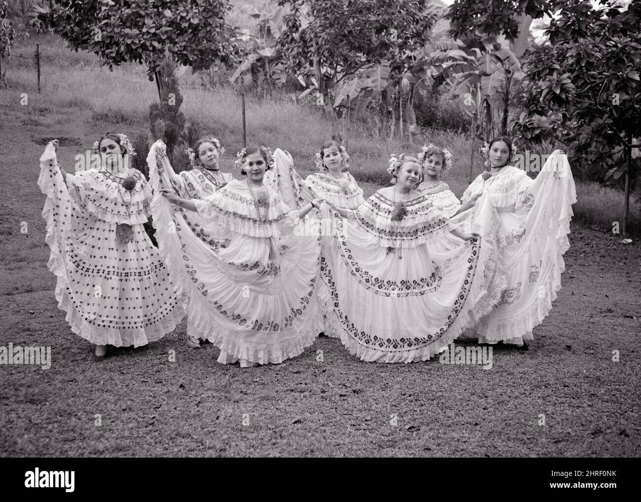 1930S 1940S 7 FRAUEN IN TRADITIONELLEN PANAMAISCHEN KOSTÜMEN DER VOLLROCK POLLERA UND OFF THE SHOULDER BLUSE PANAMA CENTRAL AMERICA - R66 PAL001 HARS SCHAUSPIELER GESCHICHTE FEIER FRAUEN LÄNDLICHEN LUXUS KOPIEREN RAUM IN VOLLER LÄNGE DAMEN PERSONEN INSPIRATION TRADITIONELLE UNTERHALTUNG VERTRAUEN B & W GARN BLICKKONTAKT DARSTELLENDE KÜNSTE WEITWINKEL STICKEREI GLÜCK PANAMA PERFORMER STILE UND SIEBEN STOLZ BLUSE ENTERTAINER BERUFE KONZEPTIONELL 7 SCHAUSPIELER KULTUR FOLK RÜSCHEN STILVOLLE KREATIVITÄT ENTERTAINER MODE KÜNSTLER JUNGE ERWACHSENE FRAU SCHWARZ UND WEISS MITTELAMERIKA BESTICKT FOLKLORISCH HANDGEFERTIGT Stockfoto