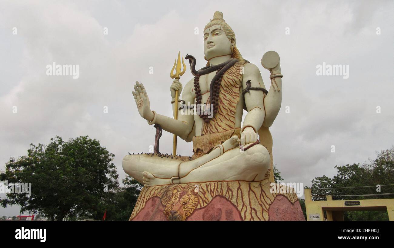 Aufnahme der Statue des Großen Gottes Shiva gegen den bewölkten Himmel in Indien Stockfoto