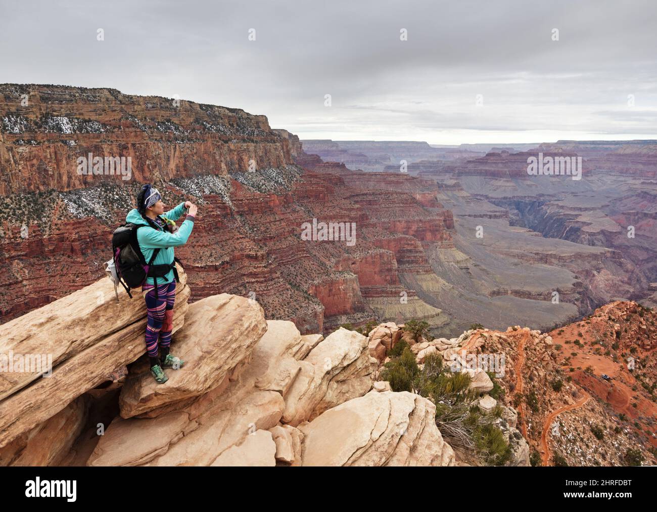 Asiatische Frau, die mit ihrem Handy ein Foto am Ooh Aah Point auf dem South Kaibab Trail im Grand Canyon National Park machte Stockfoto