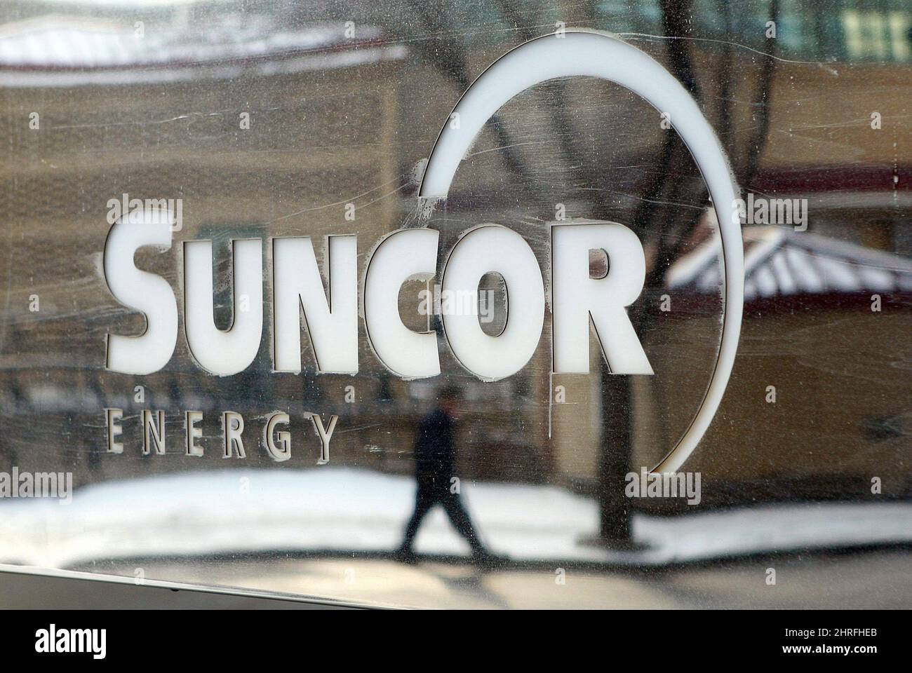 Ein Fußgänger spiegelt sich in einem Suncor Energy-Schild in Calgary, Montag, den 1. Februar 2010, wider. Suncor Energy Inc. Sagt, dass ein Mangel an Treibstoff, der Dutzende von Petro-Canada-Stationen in den vier westlichen Provinzen ohne zu pumpende Gasmenge hinterlassen hat, in den nächsten Tagen aufräumen sollte. DIE KANADISCHE PRESSE/Jeff McIntosh Stockfoto
