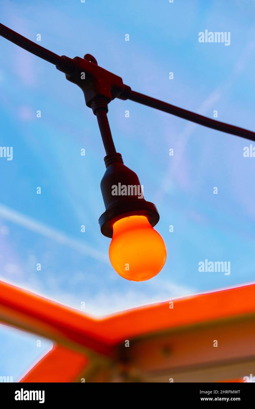 Nahaufnahme einer roten oder orangefarbenen festogenen Glühbirne am blauen Himmel im Café Billy Winters am Portland Beach Stockfoto