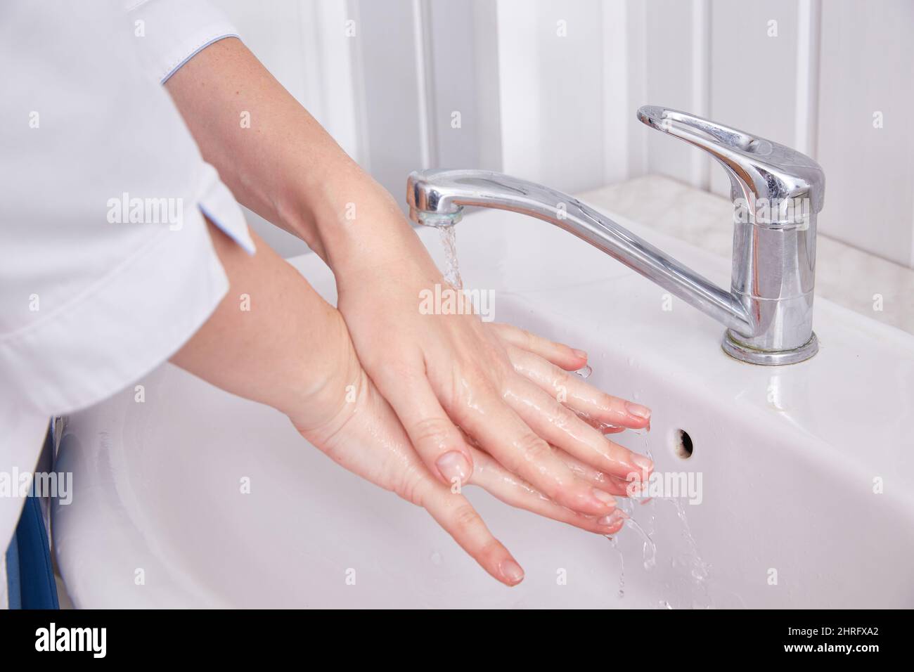 Der Arzt wäscht seine Hände vor der Operation unter fließendem Wasser. Stockfoto