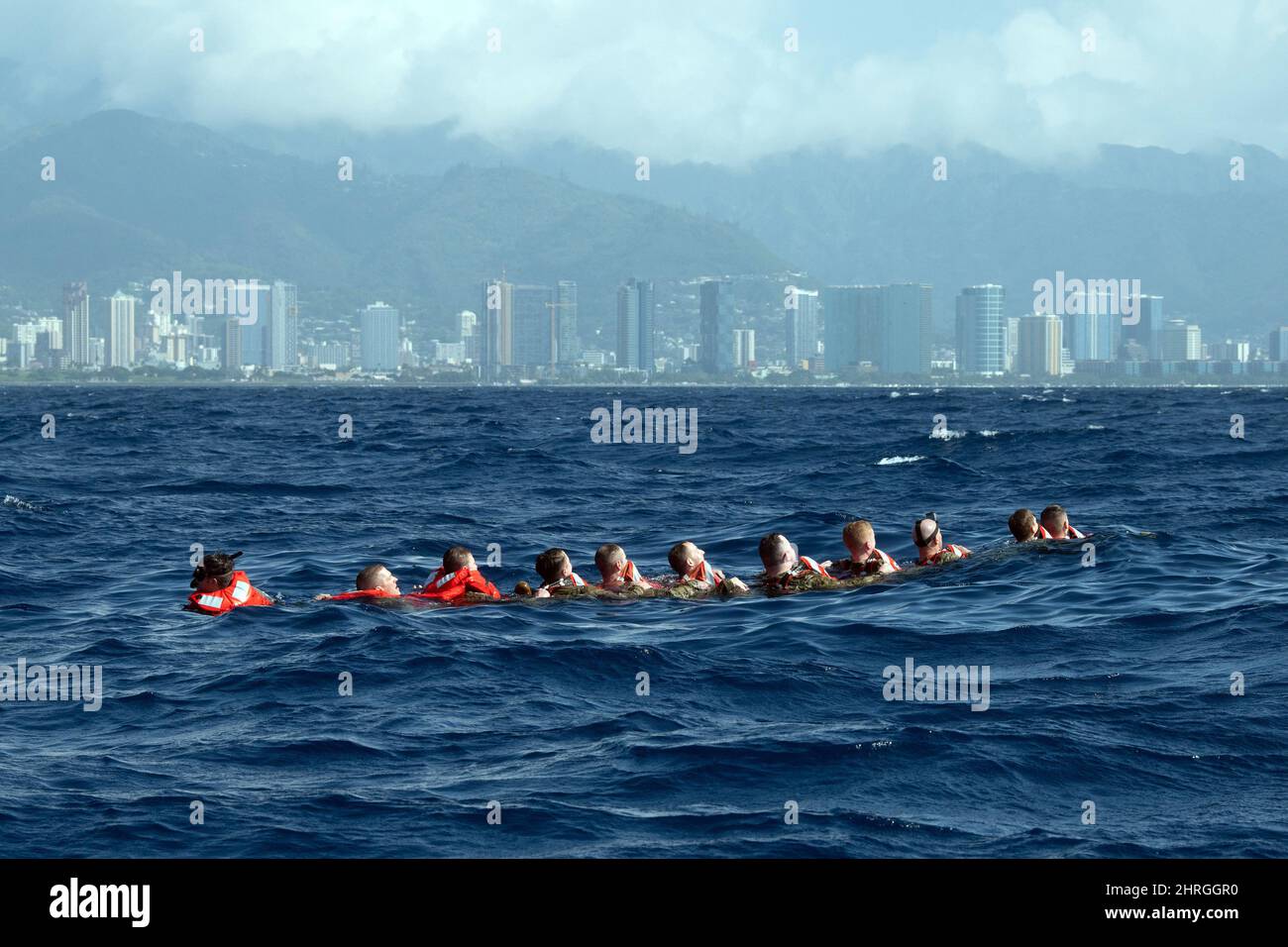 Honolulu, Hawaii, USA. 12. Januar 2022. US-Luftmänner, die dem 115. Fighter Wing Security Forces Squadron in Madison, Wisconsin, zugewiesen wurden, nehmen am Wasserüberlebenstraining vor der Küste von Honolulu, Hawaii, am 12. Januar 2022 Teil. Eine Kette zu bilden und nacheinander abzuzählen, stellte sicher, dass alle Mitglieder abgerechnet wurden, bevor sie zusammen zu einem nahegelegenen Rettungsinsel schwammen. Survival, Evasion, Resistance und Escape Instructors sorgten dafür, dass das Team von Airmen ihr Floß sicher erreichte und mit ihnen weiterhin wichtige Überlebenstechniken überprüfte, während sie im Pazifischen Ozean schwebten. (Bild: © U.S. National Stockfoto