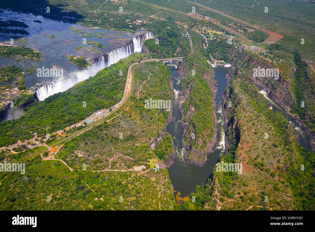 Victoria Falls zwischen Simbabwe und Sambia, Luftaufnahme des Hubschraubers, grüner Wald um riesige Wasserfälle in Afrika. Livingstone Bridge über die riv Stockfoto