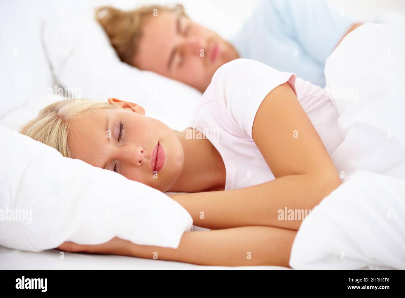 Ein paar Augen zu halten. Ein junges Paar, das zusammen im Bett schläft. Stockfoto