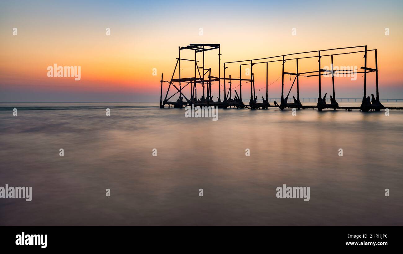 Schöner Blick auf einen Sonnenuntergang mit einem Meer im Vordergrund Stockfoto