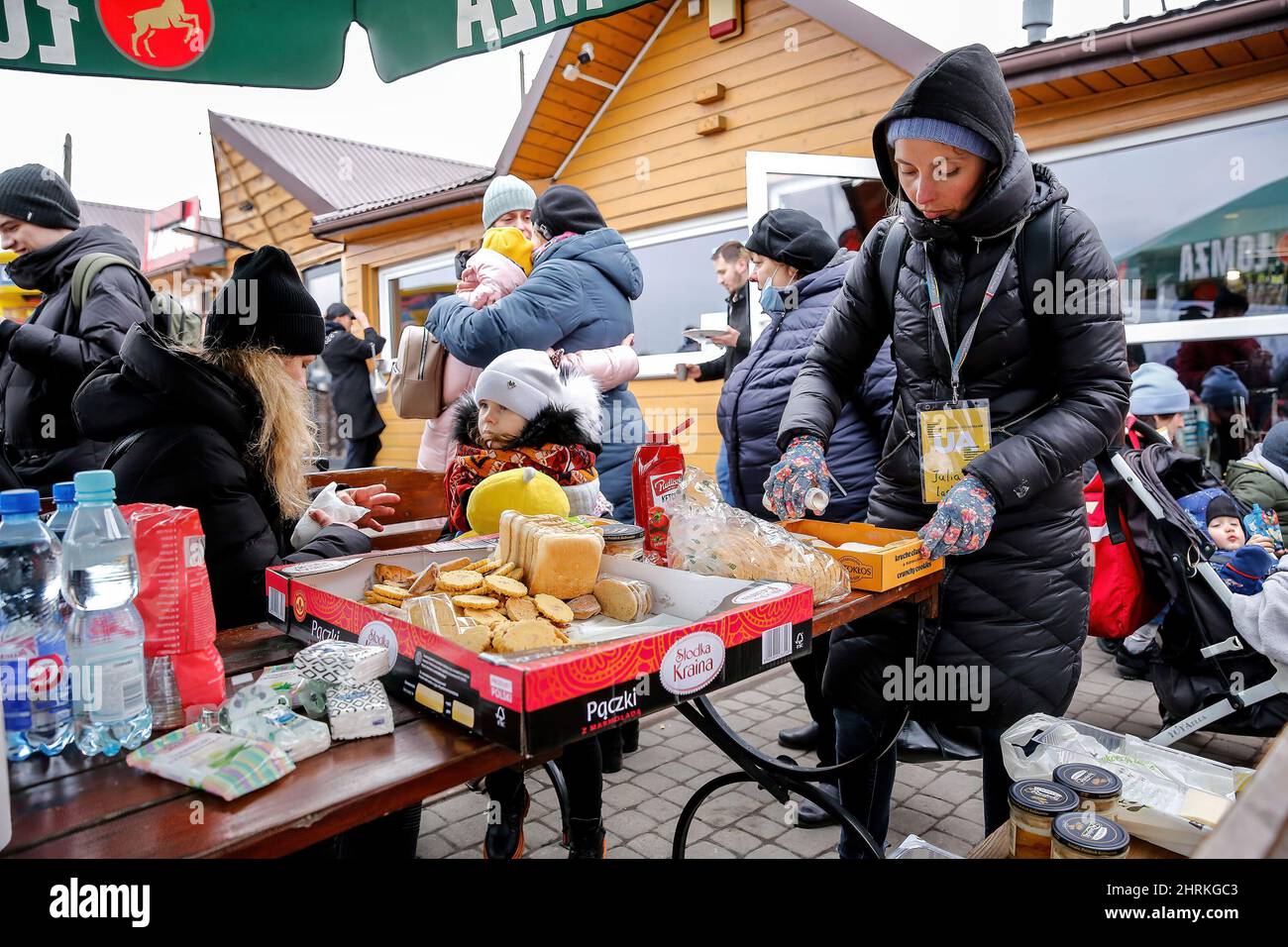 Die ukrainische Familie sah sich nach der Einreise nach Polen um die kostenlose Nahrung, die von Voluntaries zur Verfügung gestellt wurde, während Russland mehr ukrainisches Territorium einnimmt. Da die Armee der Russischen Föderation die ukrainischen Grenzen überschritten hat, wird der Konflikt zwischen der Ukraine und Russland voraussichtlich 5 Millionen Ukrainer zur Flucht zwingen. Die meisten Flüchtlinge werden in Polen Asyl beantragen. Die meisten der derzeitigen Flüchtlinge sind Familien jener Ukrainer, die bereits in Polen arbeiten. An den Grenzübergängen warten Tausende von Männern und Frauen auf ihre Angehörigen. (Foto von Dominika Zarzycka/SOPA Images/Sipa USA) Stockfoto
