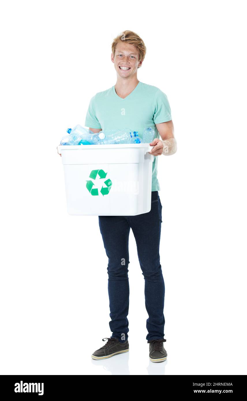 Jeder kleine Teil hilft. Ein glücklicher junger Mann mit rotem Kopf, der einen mit leeren Plastikflaschen gefüllten Recyclingbehälter in der Hand hält. Stockfoto