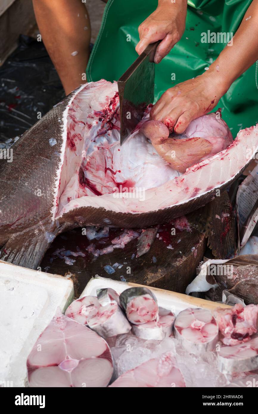 Ein lokaler Fischhändler reinigt und schneidet einen großen Fisch am Ufer von Cheung Chau, einer abgelegenen Insel Hongkongs (Sequenz - 6 von 8) Stockfoto