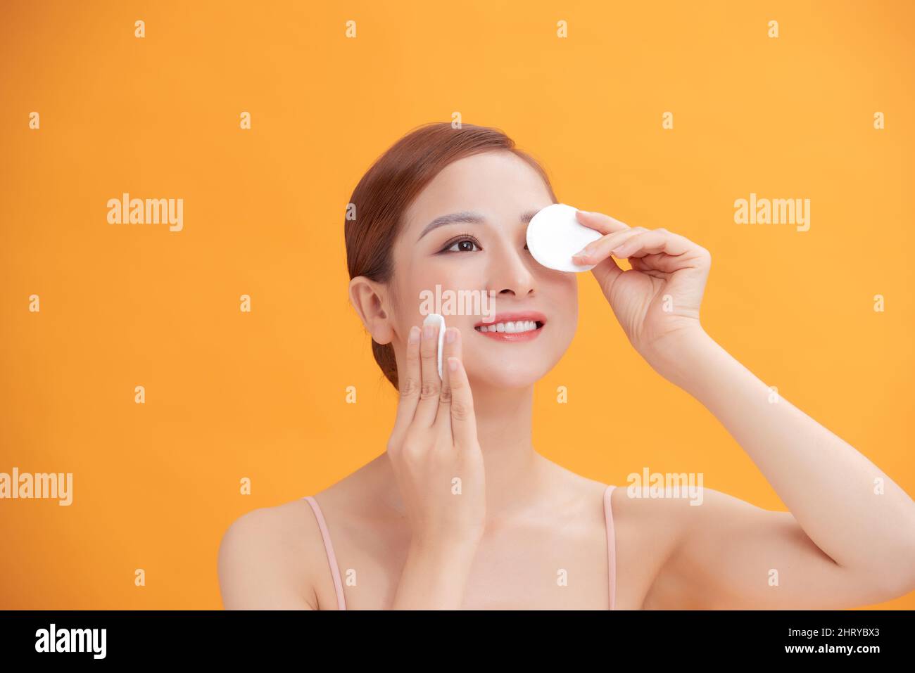 Glücklich lächelnd schöne junge Frau Reinigung der Haut durch Wattepad Stockfoto