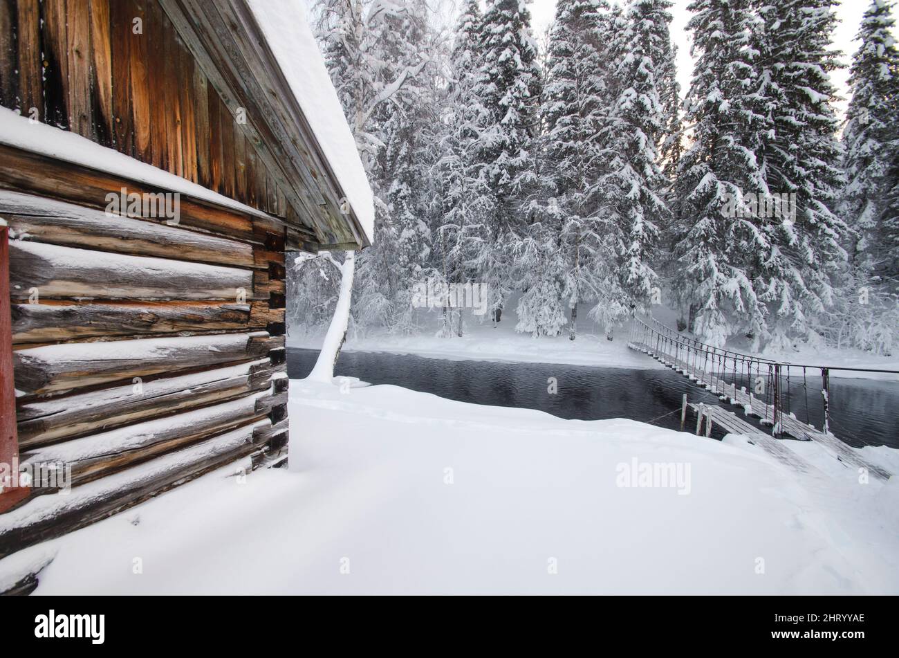 Holzbrücke über einen Waldfluss. Frostfreie Gewässer. Einfrieren. Winterlandschaft im Wald Stockfoto