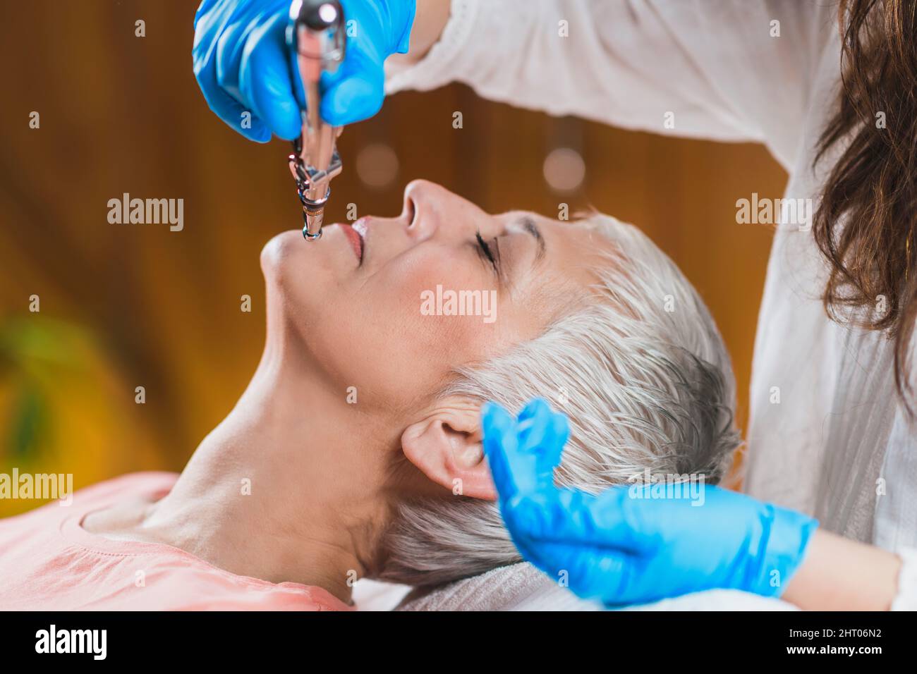 Ältere Frau, die eine Kieferbehandlung mit Meridianstift erhält Stockfoto