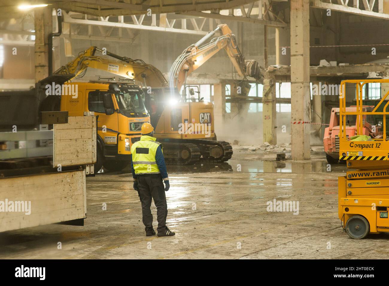 Roznov Czech Rep 4. January 2022 Arbeiter beobachten schwere Maschinen und Bagger, die Bauarbeiten in einem Industriegebäude verrichten Stockfoto