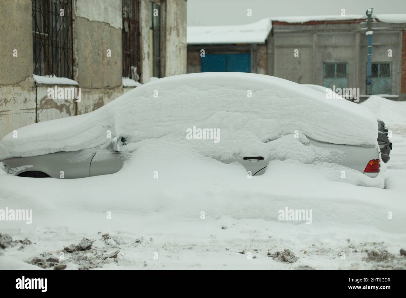 Auto unter dicker schneedecke nach sturm. unter eis begrabene fahrzeuge.  niemand