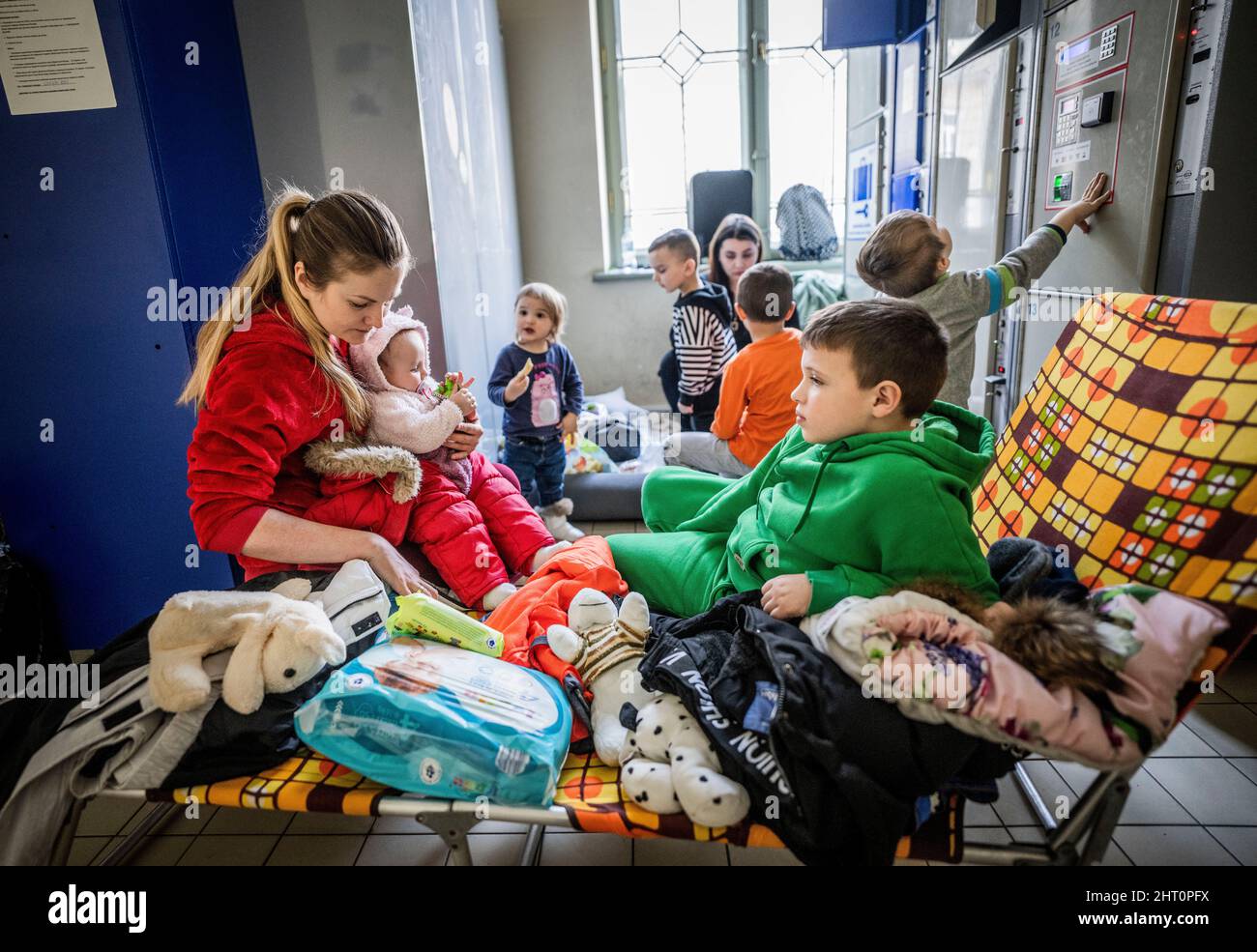 Przemysl, Polen. 26.. Februar 2022. Maria Potoschaniak mit dem Baby Alina (l.) und Sohn Bogdan (r.) aus der Ukraine haben nach der Flucht aus der Ukraine ein Lager am Bahnhof Przemysl eingerichtet. Zahlreiche Ukrainer verlassen das Land nach militärischen Aktionen Russlands auf ukrainischem Territorium. (To dpa Poland helps refugees) Quelle: Michael Kappeler/dpa/Alamy Live News Stockfoto