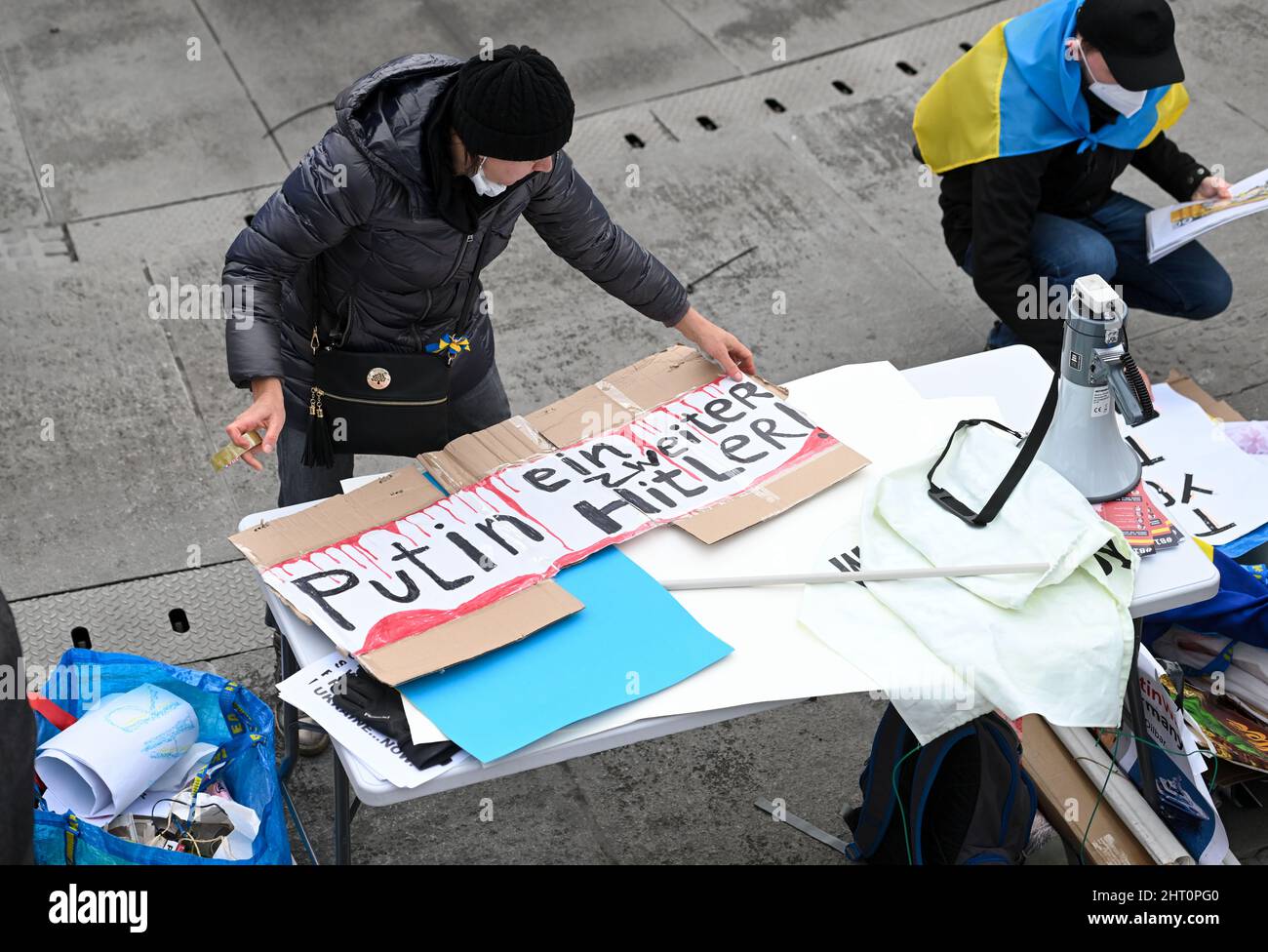 München, Deutschland. 26.. Februar 2022. Ein Demonstrator bereitet ein Plakat mit der Aufschrift "Putin ein zweiter Hitler!" vor. Am Rande einer Demonstration am Odeonsplatz gegen den Angriff Russlands auf die Ukraine. Quelle: Tobias Hase/dpa/Alamy Live News Stockfoto