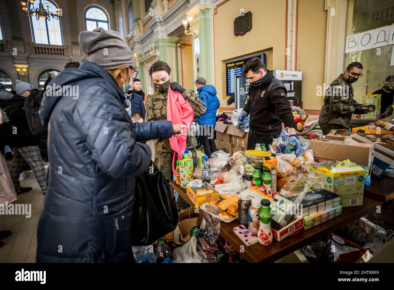 Przemysl, Polen. 26.. Februar 2022. Am Bahnhof in Przemysl verteilen Helfer Lebensmittel und Süßigkeiten an Flüchtlinge. Zahlreiche Ukrainer verlassen das Land nach den russischen Militäraktionen auf ukrainischem Territorium. (To dpa Poland helps refugees) Quelle: Michael Kappeler/dpa/Alamy Live News Stockfoto