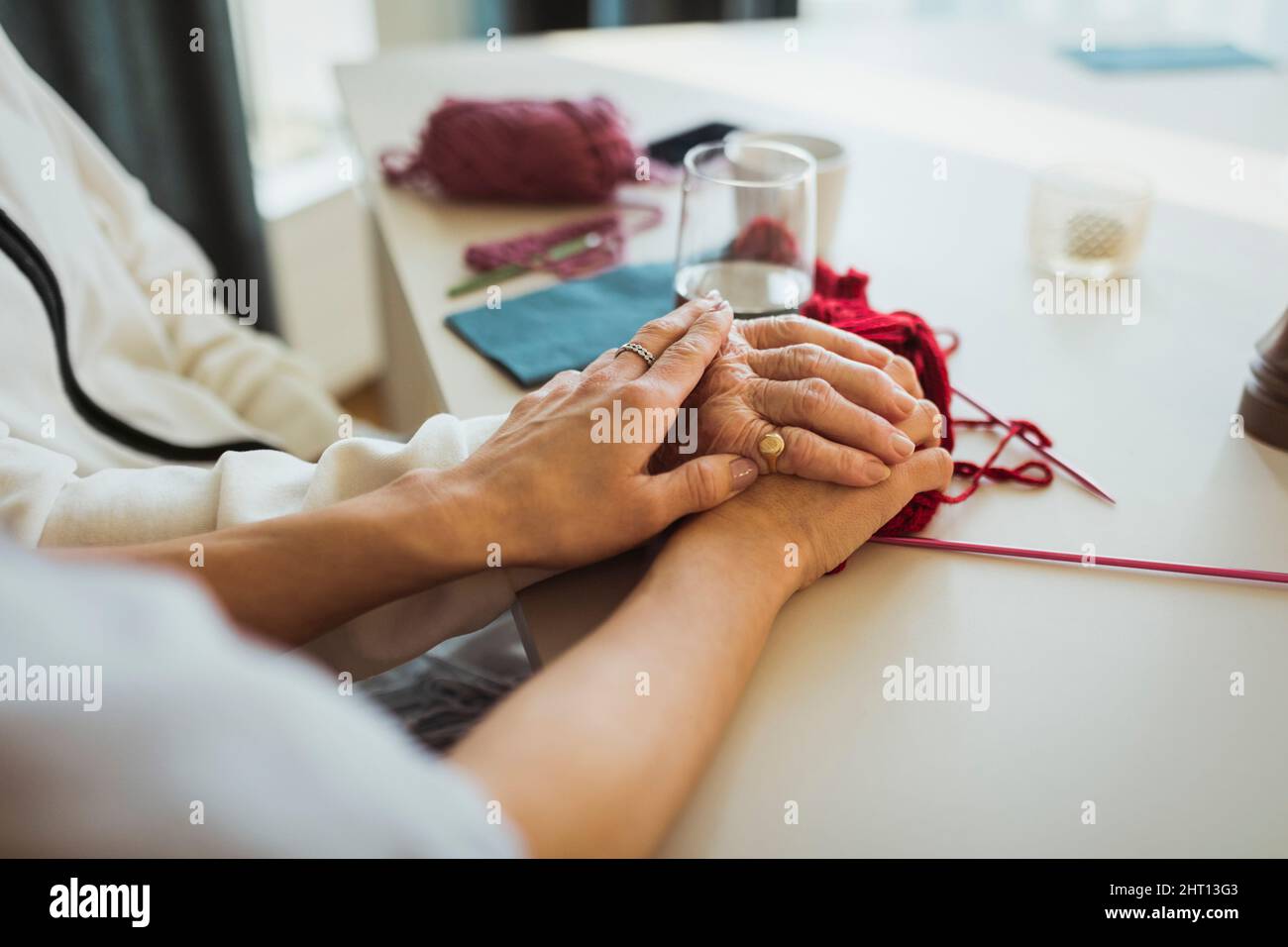 Beschnittenes Bild einer weiblichen Pflegekraft, die sich im Altersheim an ältere Frauen hält Stockfoto