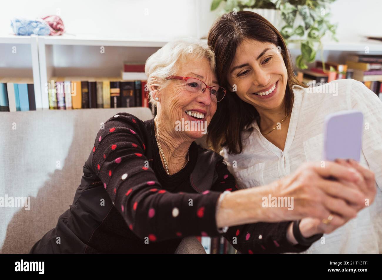 Lächelnde ältere Frau, die im Pflegeheim ein Selfie mit einer Betreuerin gemacht hat Stockfoto
