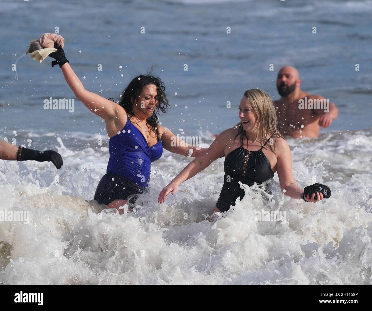 Schwimmer treffen sich mit Sol Kosepinar (nicht gesehen) im Meer an der King Edward's Bay, Tynemouth, als er seine Herausforderung abschließt, 100 Tage lang im eisigen Wasser der Nordostküste zu baden, um seine körperliche und geistige Gesundheit zu verbessern. Sol, der ursprünglich aus der Türkei stammt, stellte sich vor die Herausforderung, seine eigene psychische Gesundheit und den Stress, den er fühlt, wenn er in der Türkei abseits seiner Familie lebt, zu verbessern. Er hofft, andere dazu zu inspirieren, Meeresschwimmen zu versuchen, um ihrer eigenen psychischen Gesundheit zu helfen. Bilddatum: Samstag, 26. Februar 2022. Stockfoto