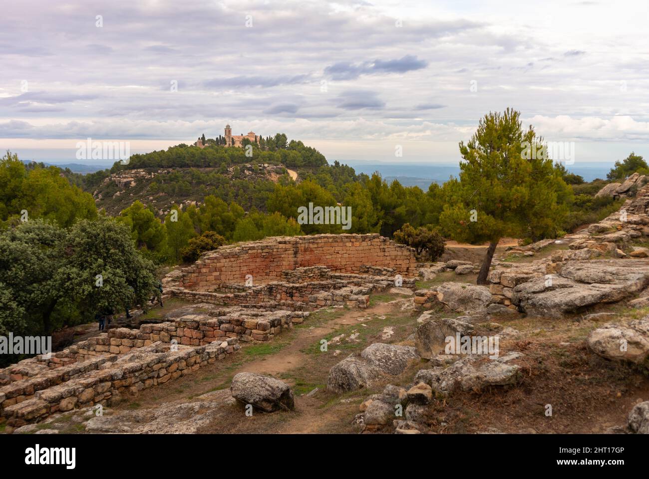 Ermitage San Cristobal und alte Ruinen einer iberischen Siedlung auf einem Hügel in der Nähe von Calaceite, Teruel, Aragon, Spanien. Stockfoto