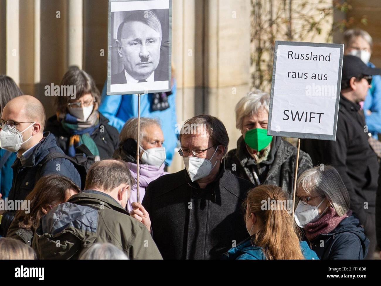 Osnabruck, Deutschland. 26.. Februar 2022. 26. Februar 2022, Niedersachsen, Osnabrück: Die Teilnehmer halten Plakate mit einem Bild des russischen Präsidenten Wladimir Putin in Bezug auf Adolf Hitler sowie der Forderung "Russland aus Swift". Ein Gebet für den Frieden in der Kirche St. Maria führt zu einem schweigenden marsch. Foto: Friso Gentsch/dpa Kredit: dpa picture Alliance/Alamy Live News Stockfoto