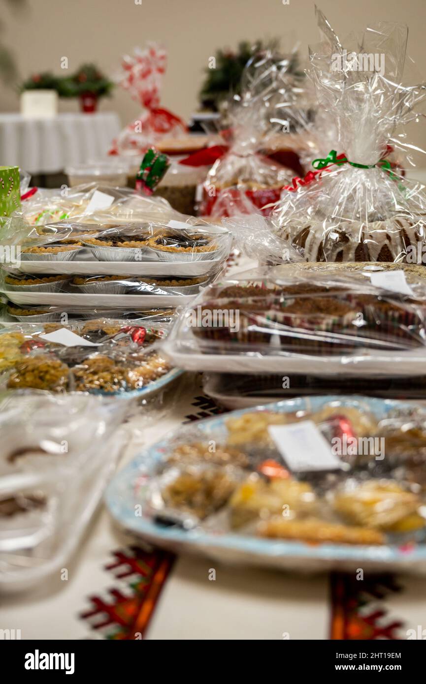 Nahaufnahme von vielen weißen Plastiktellern mit Süßigkeiten und Süßigkeiten, die mit Plastiknylon auf einem Tisch bedeckt sind Stockfoto