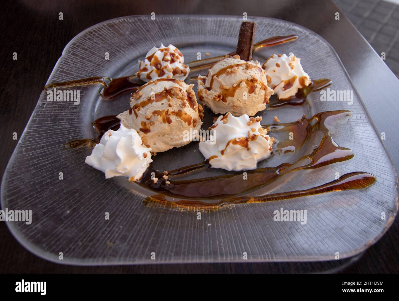 Ein sehr leckeres Dessert. Luis Felipe Mousse, Schokolade mit Creme und Karamell. Im Hintergrund eine unfokussierte Frau. Spanisches Speisekonzept. Stockfoto