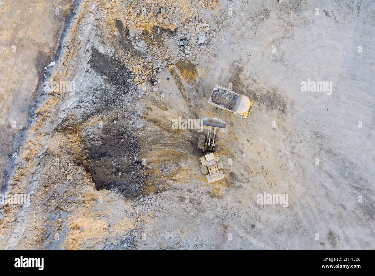 Bagger lädt Steinkies in einen LKW auf einem Schotter-Steinbruch Stockfoto