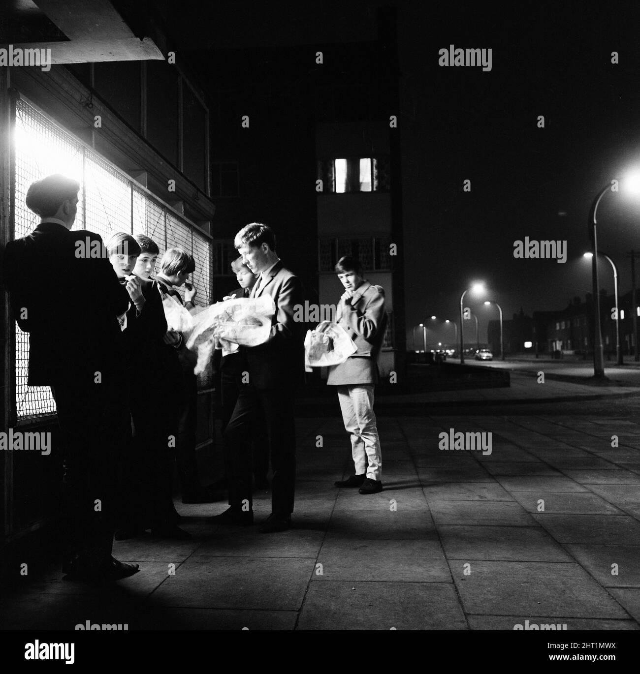 Die hellen Lichter von Kirkby, Liverpool - ein Chipshop. Der Treffpunkt, an dem sich Jugendliche aufhalten und nichts zu tun haben - für Chips im Wert von sechs Penny oder eine Flasche Pop, um den Abend zu verbringen und oft von der Polizei weiterbewegt werden. 18.. März 1965. Stockfoto