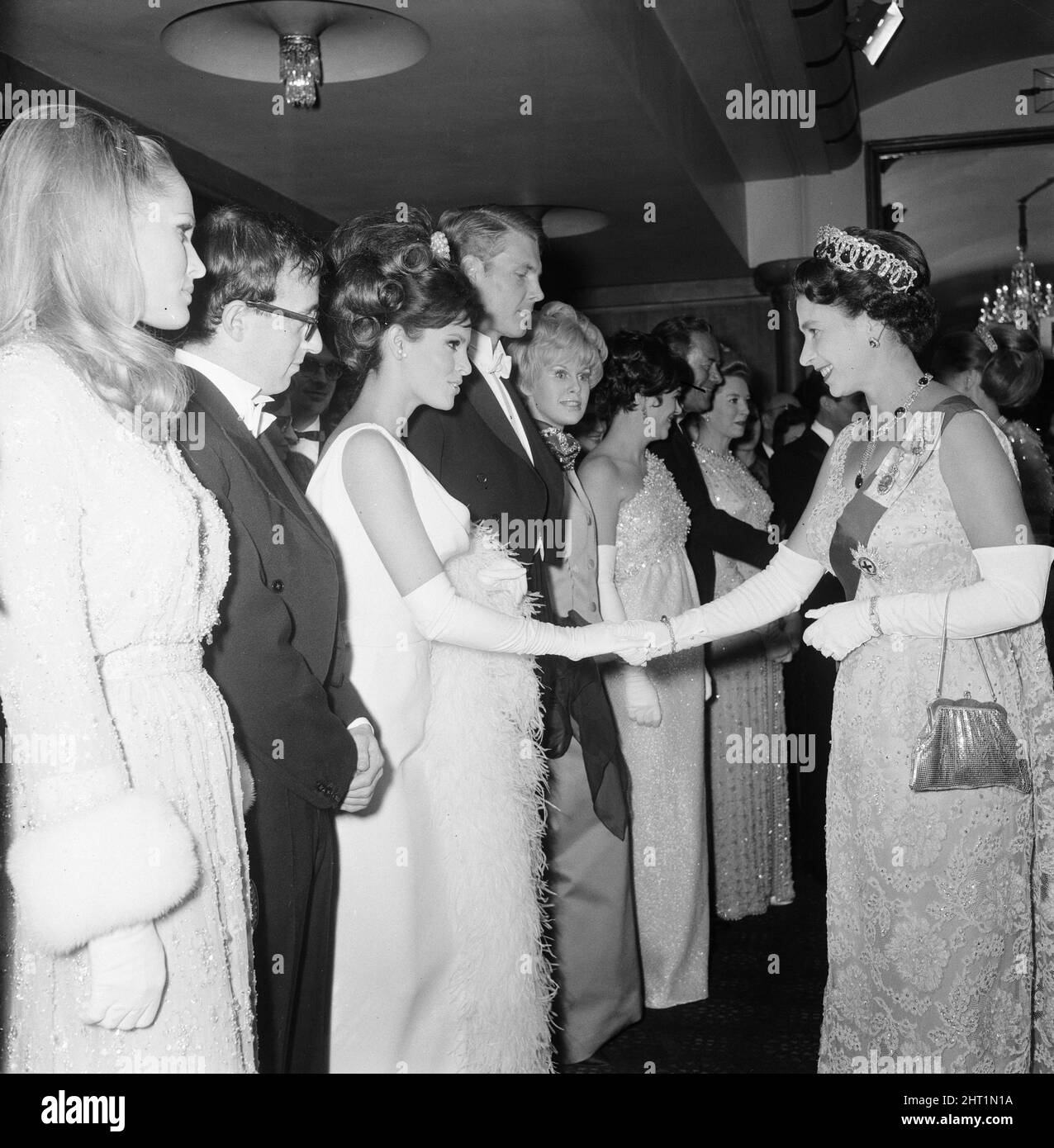 Born Free 1966, Royal Film Performance, The Odeon, Leicester Square, London, Montag, 14.. März 1966. Unser Bild zeigt... Die Königin schüttelt sich die Hände mit der ebenfalls abgebildeten Schauspielerin Raquel Welch, Ursula Andress und Woody Allen. Stockfoto