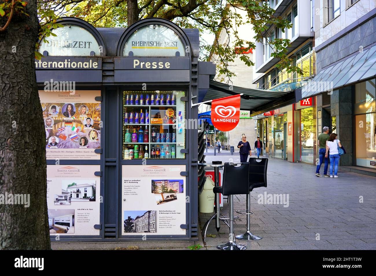 Die Einkaufsstraße Königsallee in Düsseldorf mit Vintage-Zeitungsstand. Stockfoto
