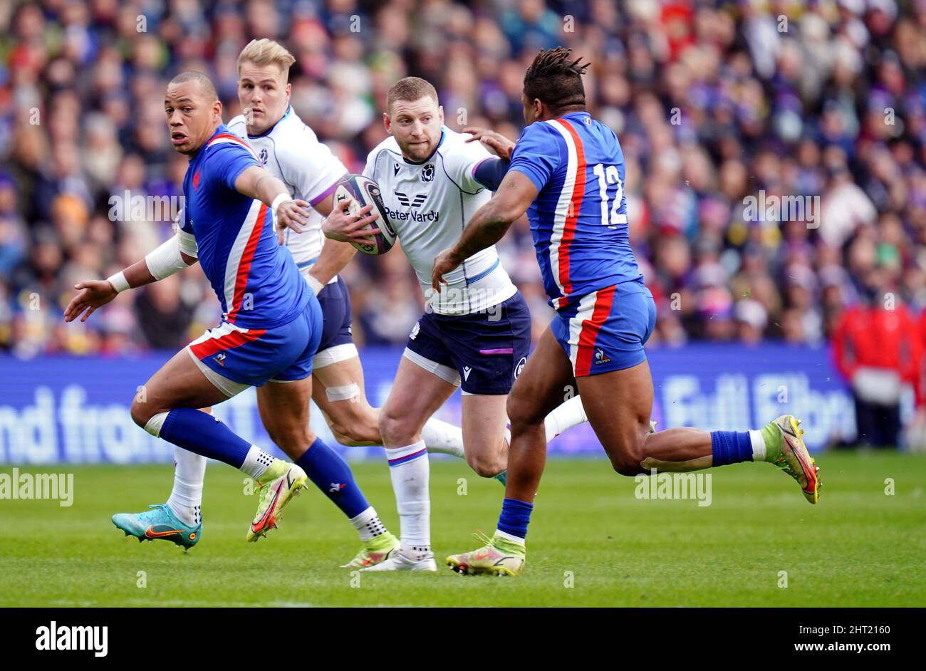 Der schottische Finn Russell übergibt den Franzosen Jonathan Danty während des Guinness Six Nations-Spiels im Murrayfield Stadium, Edinburgh. Bilddatum: Samstag, 26. Februar 2022. Stockfoto