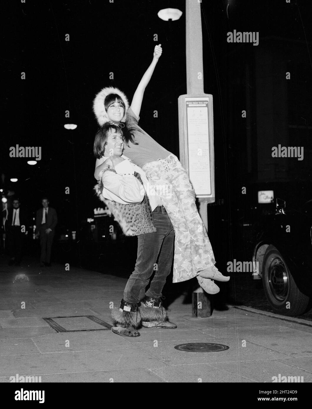 Die Pop-Sänger Sonny und Cher warten am 1965. August vor dem Hilton Hotel in London auf einen Bus Stockfoto
